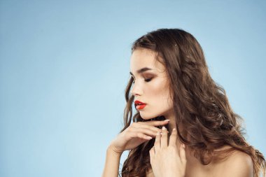 Güzel bir kadın. Çıplak omuzlar. Saç bakım, parlak makyaj, mavi arka plan.