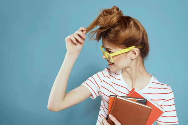 Étudiante énergique avec bloc-notes et lunettes modèle fond bleu — Photo