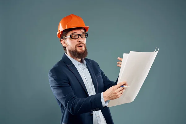 Человек в костюме в оранжевой каске чертежи в руках инженера-строителя — стоковое фото