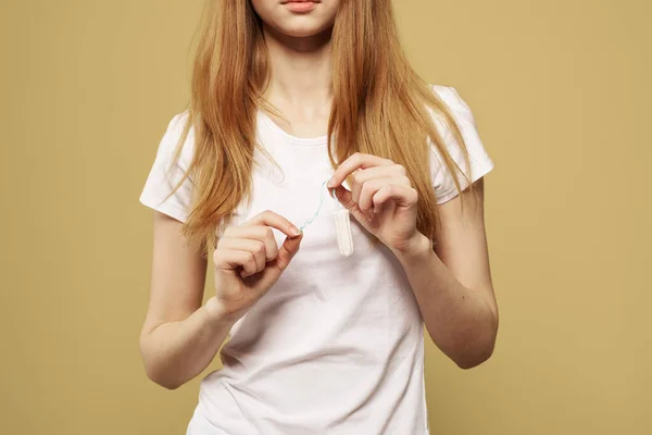 Girl with a tampon in her hand the size of the appearance of the critical days of menstruation — Stock Photo, Image