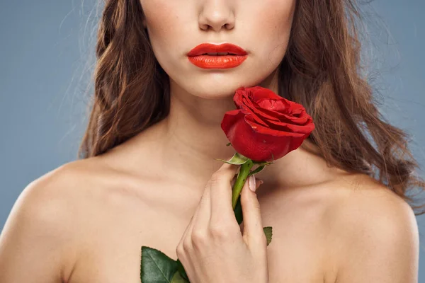 Donna con una rosa tra le mani spalle nude trucco sera labbra rosse — Foto Stock