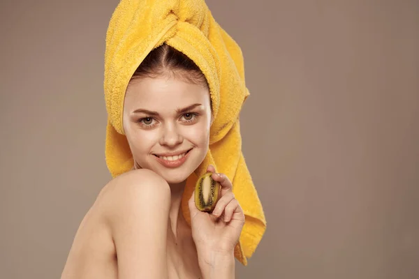 Жінка здорова там з рушником на голові чистий шкіряний фруктовий вітаміни ківі омолодження бежевий фон — стокове фото