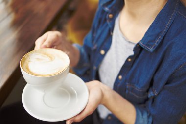 Takım elbiseli kadın zarif bir yaşam tarzı olan iletişim eğlencesi içiyor.