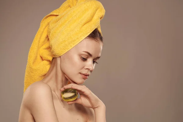 Donna con spalle nude kiwi vitamine cura della pelle stile di vita sfondo beige — Foto Stock