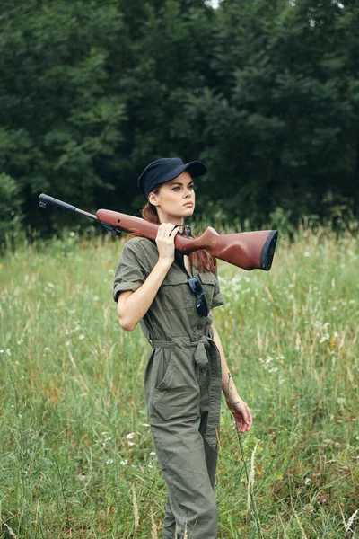 총을 들고 녹색 나뭇잎 사냥을 하는 여자 — 스톡 사진