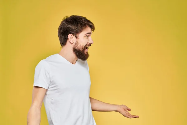 Szakállas férfi fehér póló érzelmek közelkép móka sárga háttér — Stock Fotó