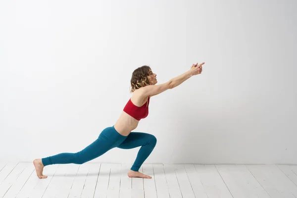 Kvinna i leggings är engagerad i gymnastik i ett ljust rum smal figur fitness sport — Stockfoto