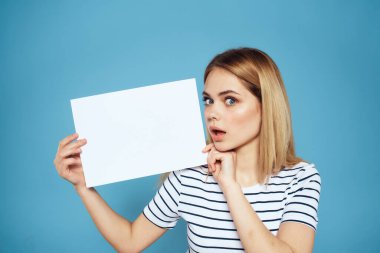 Elinde kağıt şeritli tişört tutan kadın Boşluğu kopyalanmış mavi arkaplan