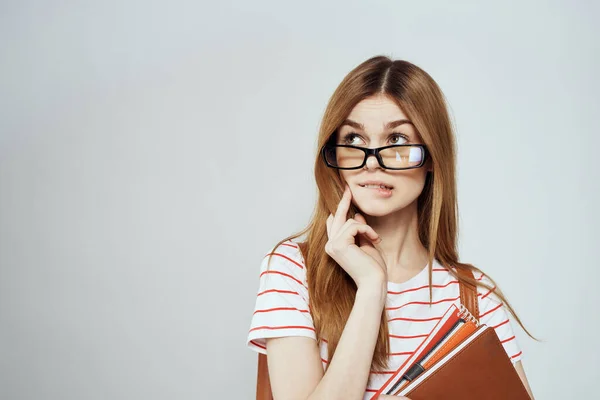 Kvinnlig student med anteckningsblock och ryggsäck på baksidan beskärda visa utbildning vetenskap glasögon — Stockfoto