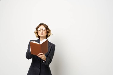 El fenerindeki kitapla çalışan kadın klasik takım elbiseli gözlüklü kafa.