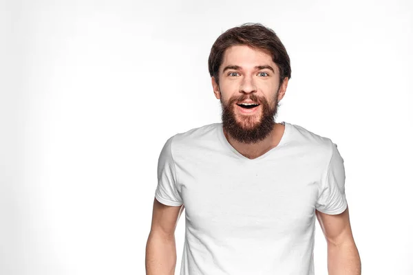 Бородатий чоловік у білій футболці жест з емоціями світлого фону — стокове фото