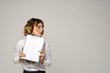 Açık tişörtlü bir iş kadını ve dosyasının içinde iş görüşü kesilmiş belgeler var.