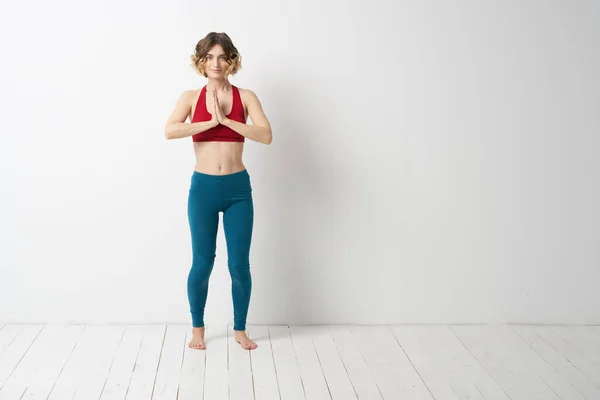 Uma mulher em pleno crescimento Em um quarto brilhante ioga meditação está envolvida em esportes — Fotografia de Stock