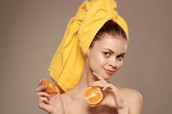 Wanita dengan handuk di kepalanya bergerigi jeruk bahu buah di tangan perawatan kulit — Stok Foto