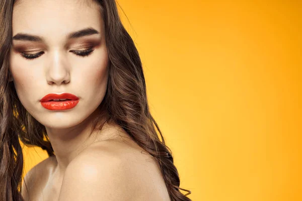 beautiful brunette red lips bare shoulders skin care yellow background