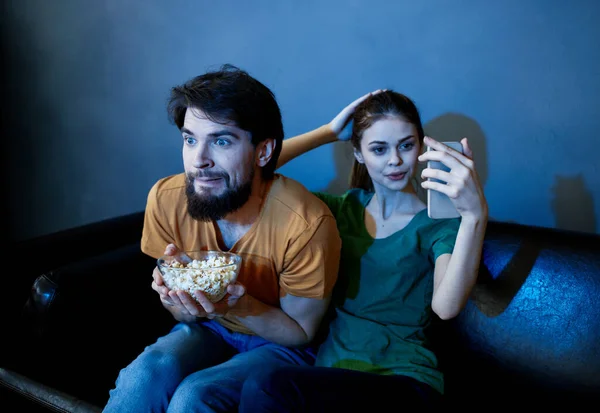 Одружена пара на дивані дивиться телевізор і попкорн в приміщенні — стокове фото
