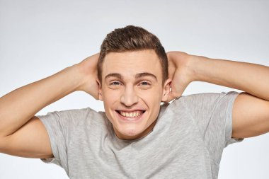 Neşeli, duygusal, gri tişörtlü, el hareketli stüdyo yaşam tarzı.