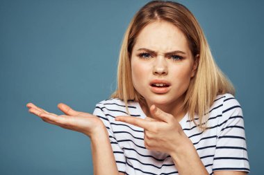 Çizgili tişört giyen bir kadın. Kırpılmış manzara. Mavi izole edilmiş arka plan.