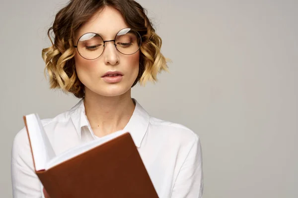 Ділова жінка з блокнотом і окулярами на світлому фоні зачіски емоції успіху — стокове фото