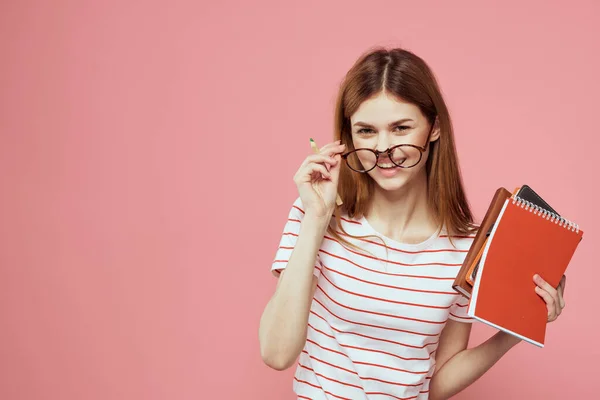 Krásná žena student držení knih vzdělávání institut gestikulace s rukama růžové pozadí kopírovat prostor — Stock fotografie