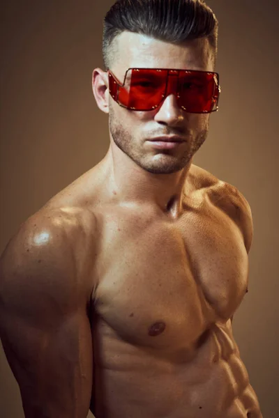 Homme sportif avec un corps musculaire gonflé portant des lunettes sombres à la mode — Photo