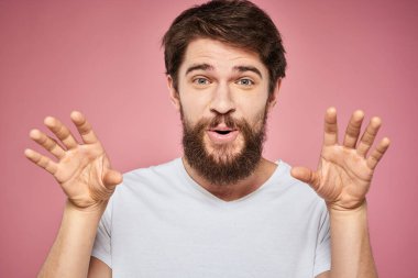 Beyaz tişörtlü adam duygu dolu yaşam tarzı yüz ifadesi pembe arkaplanı kırptı.