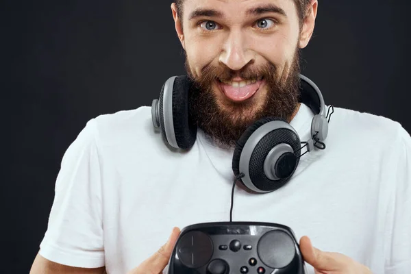 Man met joystick in handen koptelefoon technologie vrijetijdsbesteding spel levensstijl donker geïsoleerde achtergrond — Stockfoto