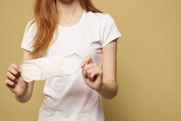 Lány egy tiszta pad a kezében egy bézs háttér vágott kilátás a menstruáció kritikus napok higiénia — Stock Fotó