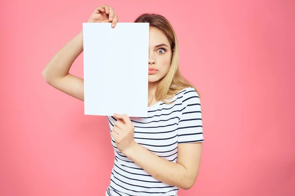 Женщина держит белый лист в руках полосатые эмоции футболки розовый фон — стоковое фото
