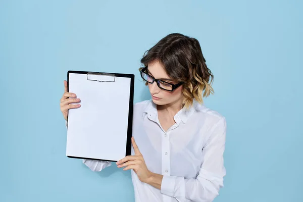 Femme d'affaires avec des documents dans un dossier sur un fond bleu et dans des lunettes de chemise légère sur son visage — Photo