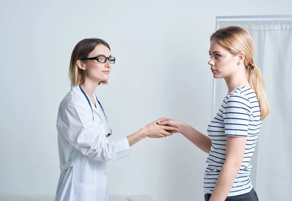 Kvinna läkare och patient skakar hand på en ljus bakgrund kommunicera medicin — Stockfoto
