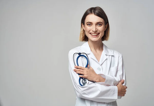 Um médico profissional com um vestido médico segura um estetoscópio na mão — Fotografia de Stock