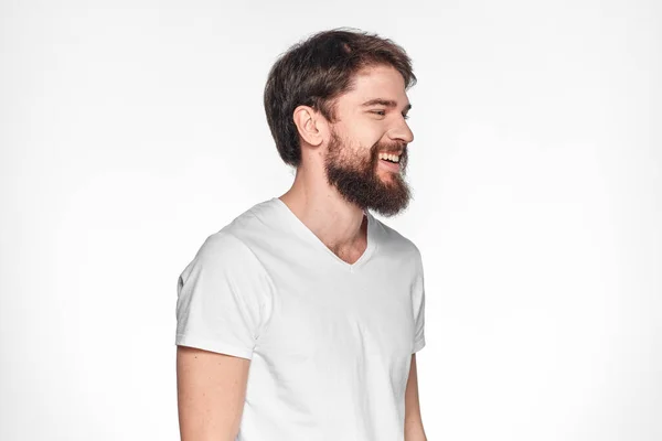 Uomo barbuto in bianco t-shirt gesto con le mani emozioni sfondo chiaro — Foto Stock