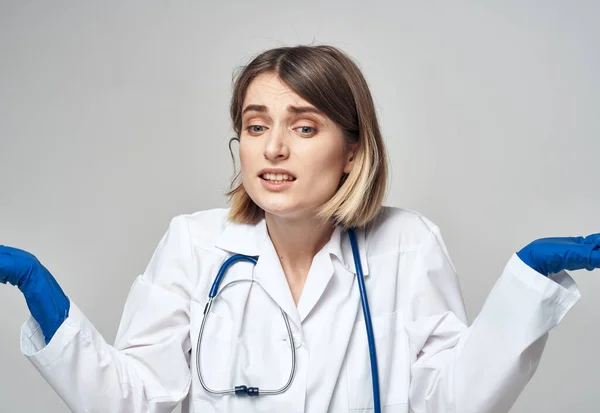 Mujer médico en un vestido médico guantes azules estetoscopio trabajo una enfermera —  Fotos de Stock