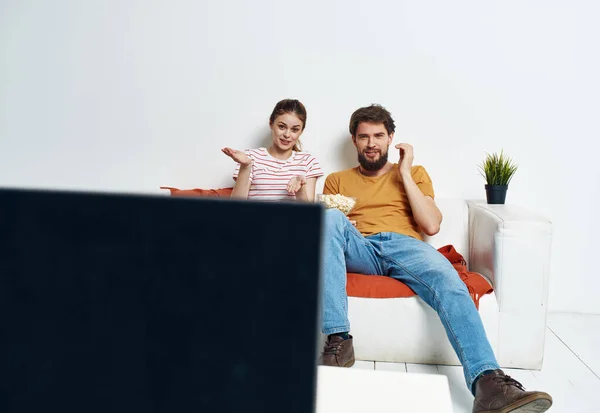 Hombre y mujer en el sofá viendo tv flor maceta — Foto de Stock