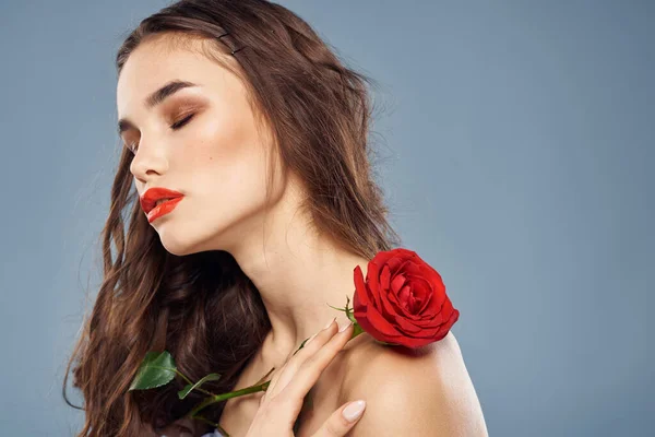 Mujer con una rosa en sus manos hombros desnudos maquillaje de noche labios rojos — Foto de Stock
