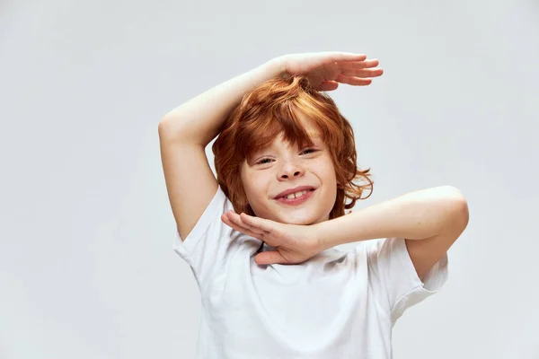 Grimmige jongen houdt handen boven het hoofd glimlach bijgesneden uitzicht — Stockfoto