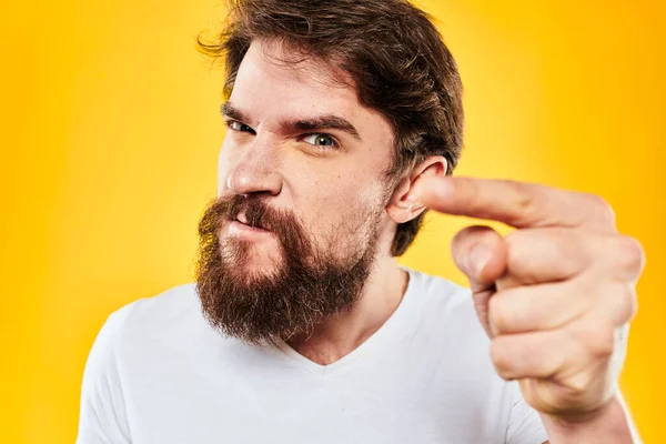 Бородатий чоловік жестикулює руками студійний спосіб життя невдоволення жовтим фоном — стокове фото
