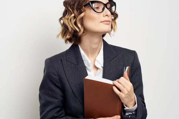 Femme d'affaires dans un costume classique avec un cahier à la main et des lunettes sur son visage Espace de copie — Photo