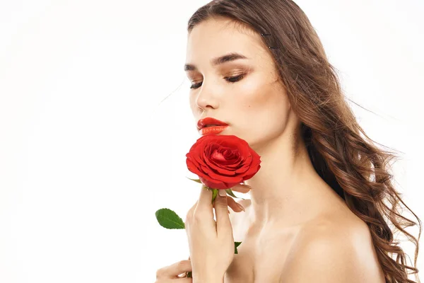 Žena s nahými rameny a červenou růží večer make-up světlo na pozadí — Stock fotografie