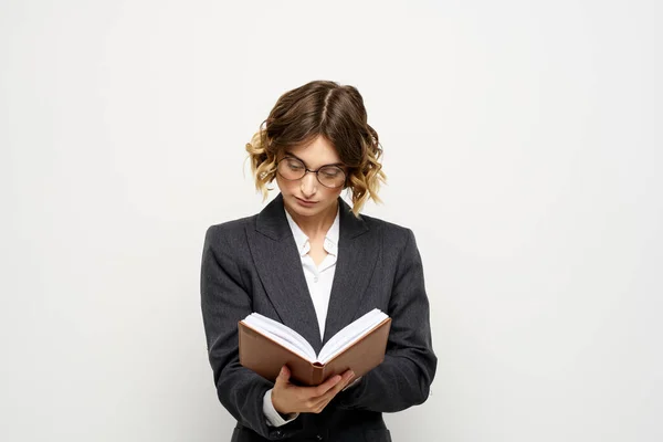 Obchodní žena v obleku s dokumenty v ruce světlé pozadí kudrnaté vlasy účes — Stock fotografie