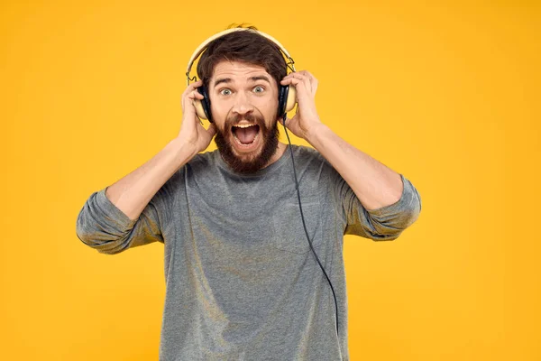 Άνθρωπος με ακουστικά ακούγοντας μουσική lifestyle στούντιο τεχνολογίας κίτρινο φόντο — Φωτογραφία Αρχείου