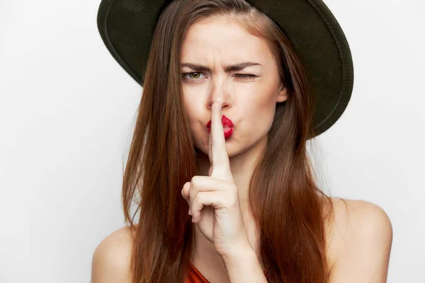 Retrato de una mujer en un sombrero Silencio sostiene un dedo cerca de su boca mirada sexy — Foto de Stock