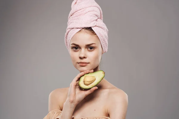 Mulher alegre com uma toalha na cabeça vista cortada de um abacate na mão — Fotografia de Stock