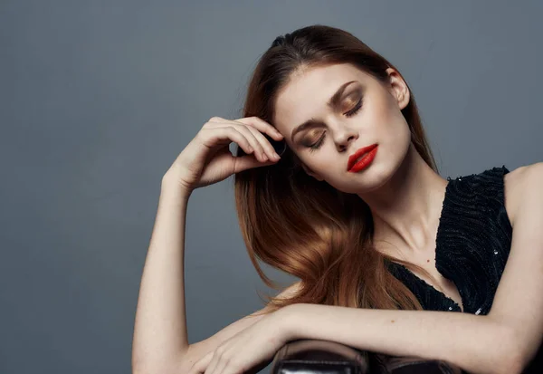 Retrato de una mujer elegante en vestido negro maquillaje de noche y labios rojos fondo gris — Foto de Stock