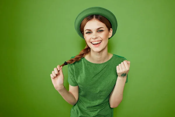 Bella ragazza con un trifoglio sulla mano su uno sfondo verde vacanze St. Patricks Day divertente cappello sulla testa — Foto Stock