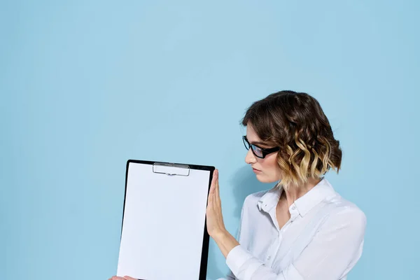 Деловая женщина с документами в папке на синем фоне и в светлых очках на лице — стоковое фото