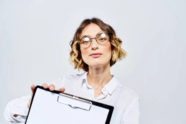 Donna d'affari con una cartella di documenti bianchi in mano su uno sfondo chiaro e modello di occhiali per acconciatura — Foto Stock