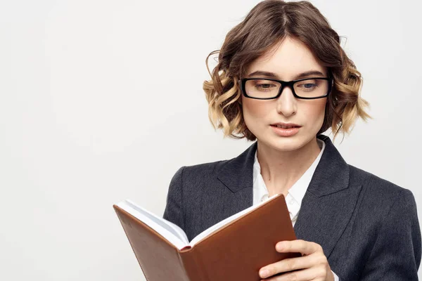 Mujer de negocios con bloc de notas y gafas de trabajo luz fondo recortado vista del modelo de traje. — Foto de Stock