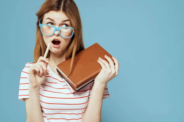 Fille dans des lunettes à la mode avec des ordinateurs portables dans les mains sur un fond bleu vue recadrée Espace de copie — Photo